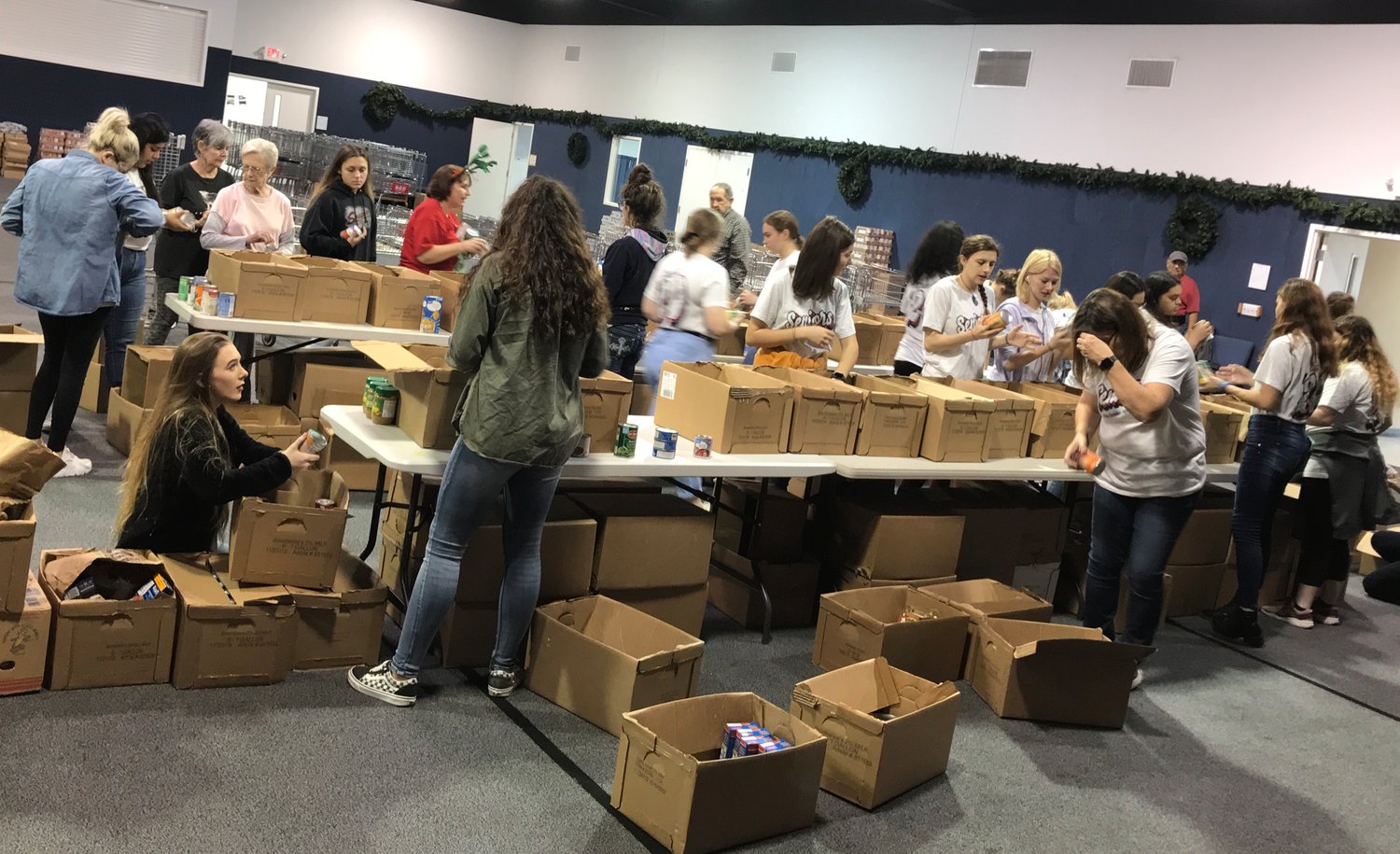 Volunteers pack food boxes during last year’s Mineola Caring and Sharing effort that reached more than 1,000 residents of the Mineola school district with food and gifts. (Courtesy photo)